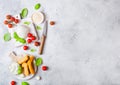 Fresh Mozzarella cheese on vintage chopping board with tomatoes and basil leaf and tray with cheese sticks on stone kitchen table Royalty Free Stock Photo