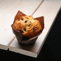 Fresh muffin with raisins in paper wrapper