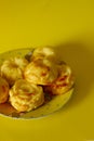 Fresh muffins on exquisite traditional plate on yellow backround
