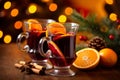 Fresh mulled wine on a wooden table on a backdrop of Christmas lights. Traditional hot Christmas drink served with spices and