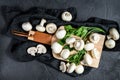 Fresh mushrooms champignon on a wooden cutting Board. Black background. Top view Royalty Free Stock Photo