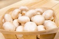 Fresh mushrooms champignons in a basket on a wooden background Royalty Free Stock Photo