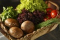 Fresh mushrooms, lettuce, parsley, tomatoes, chives on an old wooden tray. Royalty Free Stock Photo