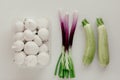Fresh mushrooms white champignons in plastic packaging and green onions shallots or scallions on white background. Royalty Free Stock Photo