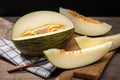 Fresh Muskmelon with slices on wooden table