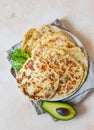 Fresh naan bread with avocado and sprouts, concrete background. Traditional homemade wheat flour flatbread on plate. Top view