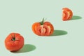 Fresh natural jummy tomato lion heart, half and slice against pastel green background..Minimal and optimistic concept