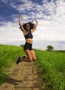 Natural lifestyle portrait of young attractive and happy hipster woman with curly hair feeling free jumping on the air enjoying Royalty Free Stock Photo