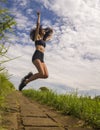 Natural lifestyle portrait of young attractive and happy hipster woman with curly hair feeling free jumping on the air enjoying Royalty Free Stock Photo