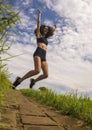 Natural lifestyle portrait of young attractive and happy hipster woman with curly hair feeling free jumping on the air enjoying Royalty Free Stock Photo