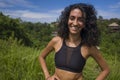 Natural lifestyle portrait of young attractive and happy hipster woman with curly hair in fitness clothes enjoying nature outdoors Royalty Free Stock Photo