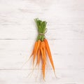 Fresh natural organic carrots bunch light wooden background. Autumn summer harvest concept. Top view . Rustic style.