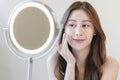 Fresh, nice healthy skin, beautiful of asian young woman, girl looking at mirror, touching her face with before make up cosmetic Royalty Free Stock Photo