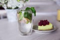 Fresh non-alcoholic mojito and slice of raspberry cake on the table in the cafe. Summer food Royalty Free Stock Photo