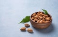 Fresh nuts almonds in a wooden bowl on a blue background