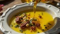 Fresh olive oil pouring into dish with floating herbsspices Royalty Free Stock Photo