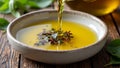 Fresh olive oil pouring into dish with floating herbsspices Royalty Free Stock Photo