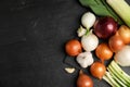 Fresh onion bulbs, leeks and garlic on black table, flat lay. Space for text Royalty Free Stock Photo