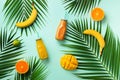 Fresh orange, banana, pineapple, mango smoothie and juicy fruits on palm leaves over blue background. Detox summer drink Royalty Free Stock Photo