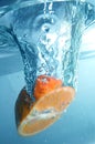 Fresh orange into blue, clear water Royalty Free Stock Photo