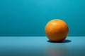 Round orange fruit in a sunlight on a blue background