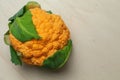 Head of an orange cauliflower with green leaves Royalty Free Stock Photo