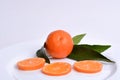 Fresh orange clementines with leaves cut in slices