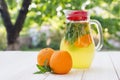 Fresh orange drink in the glass jar. Still life glass jar with orange-mint drink on the wooden table on the natural blurred Royalty Free Stock Photo