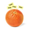 Fresh orange with E numbers isolated. Harmful food additives Royalty Free Stock Photo
