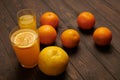 Fresh orange fruits whole and sliced on a dark wooden background - natural and healthy food. Glass of fruit cocktail Royalty Free Stock Photo