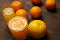 Fresh orange fruits whole and sliced on a dark wooden background - natural and healthy food. Glass of fruit cocktail Royalty Free Stock Photo