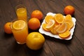 Fresh orange fruits whole and sliced on a dark wooden background - natural and healthy food. Glass of fruit cocktail Royalty Free Stock Photo