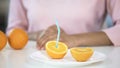 Fresh orange half with straw in front of young woman on plate, healthy lifestyle Royalty Free Stock Photo