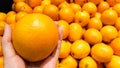 An orange on a hand with group of oranges in supermarket Royalty Free Stock Photo