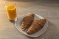 Fresh orange juice with croissants on wooden table. Royalty Free Stock Photo