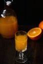 Fresh orange juice in crystal glass with fresh fruits on dark wood table Royalty Free Stock Photo