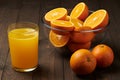 Fresh orange juice and fruits whole and sliced on a wooden table - natural and healthy food and drink. One glass of cocktail Royalty Free Stock Photo