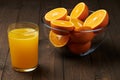 Fresh orange juice and fruits whole and sliced on a wooden table - natural and healthy food and drink. One glass of cocktail Royalty Free Stock Photo