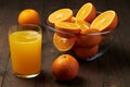 Fresh orange juice and fruits whole and sliced on a wooden table - natural and healthy food and drink. One glass of cocktail Royalty Free Stock Photo