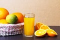 Fresh orange juice in glass beaker and whole oranges in basket on a table. Sliced orange slices and orange juice Royalty Free Stock Photo