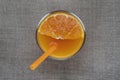 Fresh orange juice glass with orange straw over sack fabric background Royalty Free Stock Photo