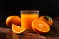 Fresh orange juice in glass and oranges fruit on wooden table background. Royalty Free Stock Photo