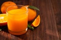 Fresh orange juice in glass and oranges fruit on wooden table background Royalty Free Stock Photo