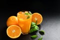 Fresh orange juice in glass surrounded by oranges