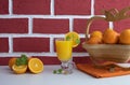 Fresh orange juice in a glass glass on a table, back whole and sliced oranges Royalty Free Stock Photo