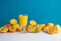 Fresh orange juice in a glass and on the table a lot of fresh oranges and fruits Royalty Free Stock Photo