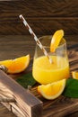 Fresh orange juice in glasses with cut oranges on wooden tray. Rustic still life with citrus fruits Royalty Free Stock Photo