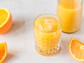 Fresh orange juice with ice cubes in a glass on a table. Royalty Free Stock Photo