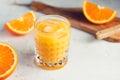 Fresh orange juice with ice cubes in a glass on a table. Royalty Free Stock Photo