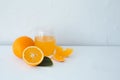 Fresh orange juice with oranges and orange slices on white table
